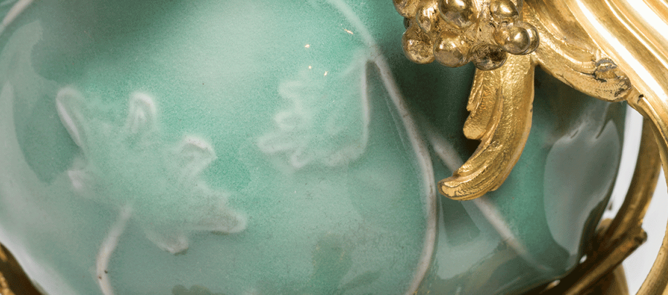 close up of green jade vase with gold details