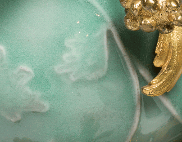 close up of green jade vase with gold details