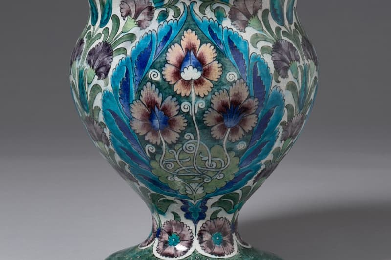 A ceramic vase with a multicolored, stylized botanical motif.