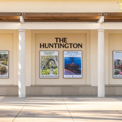 A building wall with six posters and a sign that reads “THE HUNTINGTON.”